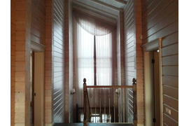 Так выглядит лестничное окно со шторами после демонтажа вышки. В противоположном краю коридора похожее окно с меньшей высотой, оформлено в этом же стиле.