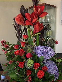 Вертикальный букет в корзине из гортензий, амариллиса, лотоса, красных роз и леукадендрона