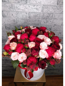 Букет из красных пионовидных роз, скиммии, розы бомбастик в шляпной коробке. Недорогой букет.
