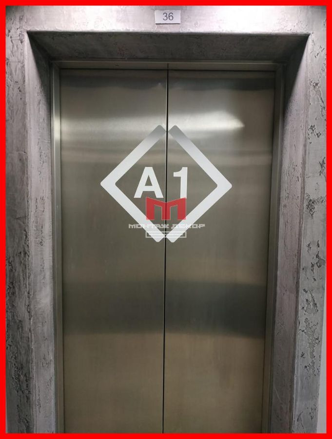 Наклейка из белой матовой пленки с плоттерной резкой логотипа на внешних створках лифта