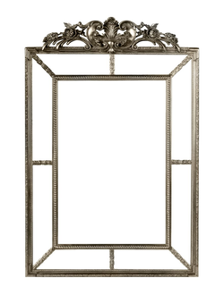 Зеркало в серебряной раме в стиле “барокко” с цветочным орнаментом сверху.