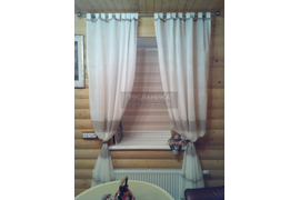Шторы на петлях на окне в бане с рулонными шторами на заднем фоне.