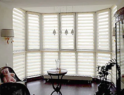 Кремовые рулонные шторы день-ночь  в эркер для светлой комнаты с темными полами и деревянной мебелью. Неоклассика