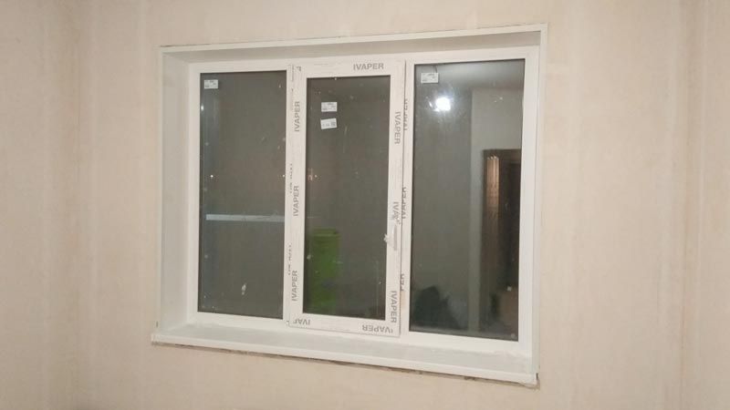 Трехстворчатое окно белого цвета после отделки и установки подоконника и откосов