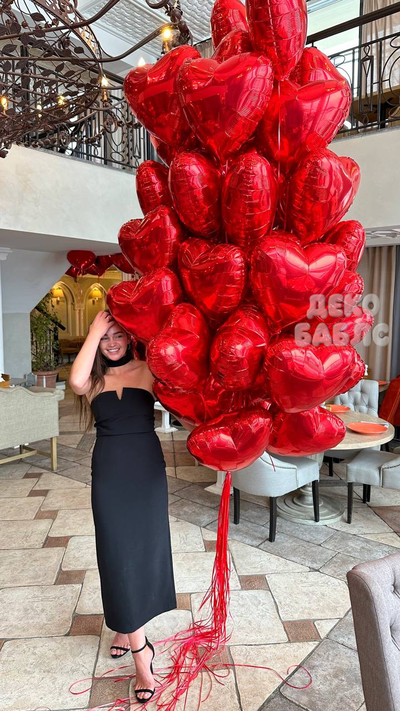 Огромная охапка из сотен красных фольгированных сердец с гелием, закрывающая человека в полный рост