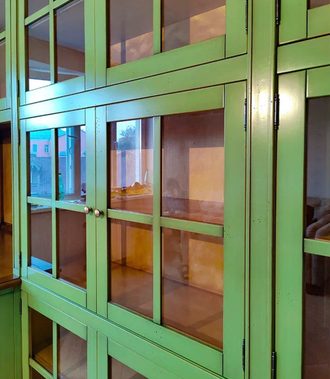 Библиотека со стеклянными дверьми и встроенным рабочим столом.