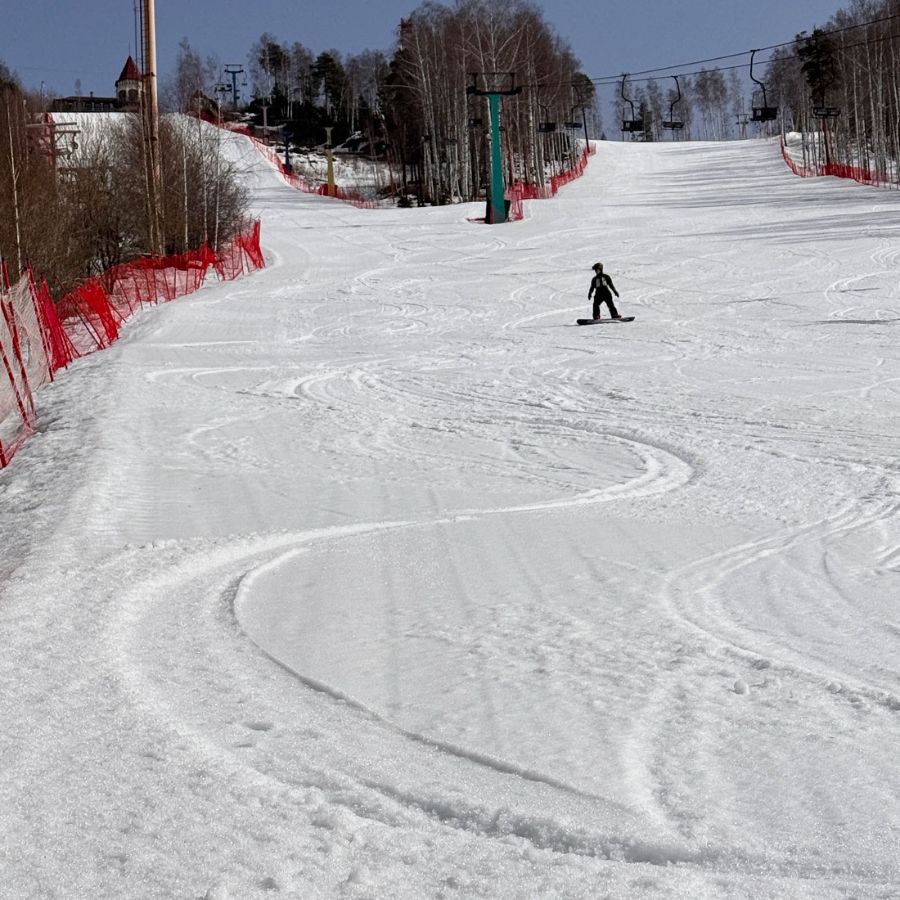 Сноуборд инструктор Анна катится по весеннему снегу на Ежовой