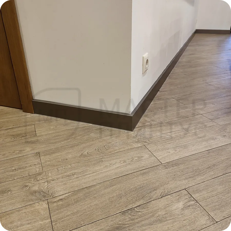 Бронзовый шик: установка плинтуса Dollken с бронзовым покрытием добавляет интерьеру современный лоск и элегантность.