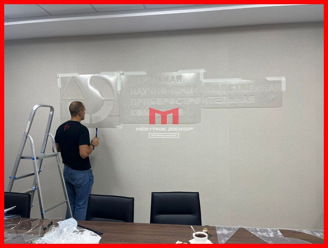 Монтаж трафаретов для установки логотипов на стену в офисе