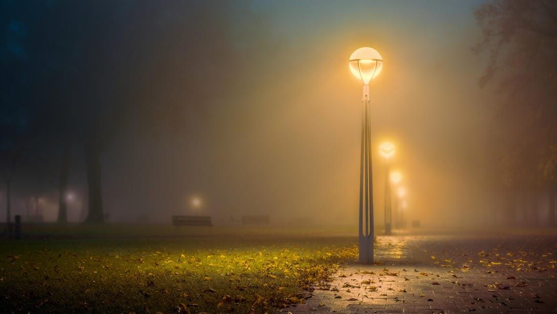 Металлическая опора освещения типа торшер в вечернем парке