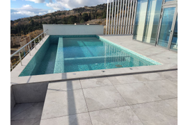 Частный переливной бассейн в мозаике, с гидромассажной зоной.