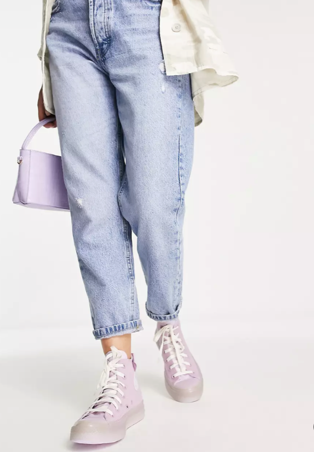 розовые кеды Converse на ноге с джинсами