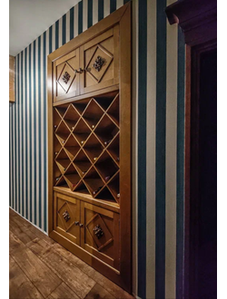 Встроенный винный шкаф с резными декорами на дверях.