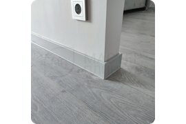 Практичный выбор: монтаж серого плинтуса Dollken Cubu Flex Life 80 - функциональное решение для помещений с неровными стенами, обеспечивающее безупречное прилегание.