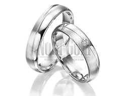 Классические обручальные кольца из платины с ассиметричной дорожкой с бриллиантом в женском кольце