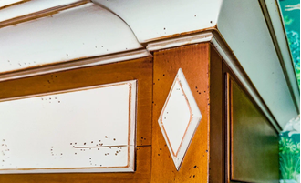 Шкаф для одежды с резным декором на фасадах и нижним ящиком.