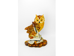 Сова с пером на книгах на подставке