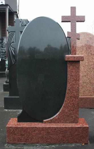 На фото круглый памятник на могилу красно-черный с крестом