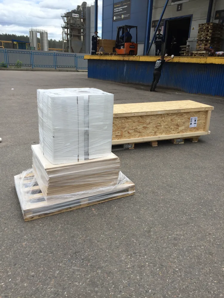 Пример жесткой упаковки, которую мы используем для перевозки стеновых панелей и штапика из массива дерева длиной 2,2 метра - изготовленный деревянный ящик, выставленный на паллеты. Также, виден пример упаковки других стеновых панелей.