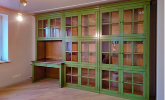 Библиотека со стеклянными дверьми и встроенным рабочим столом.