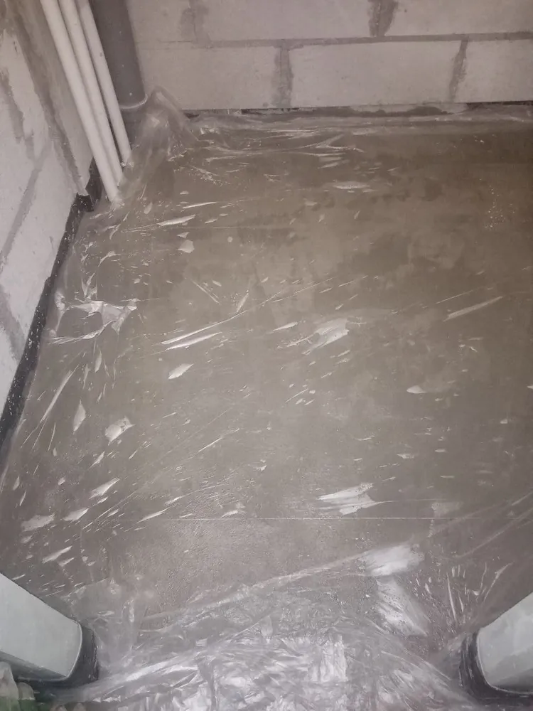 Стяжка, после заливки накрывается целлофаном. Вода должна равномерно вступить в реакцию с цементом в растворе.