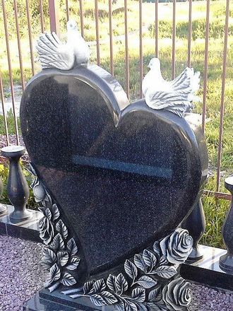 На фото маленький надгробный памятник на могилу с голубями в СПб