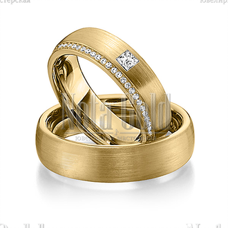 Обручальные кольца из жёлтого золота с дорожкой бриллиантов и одним крупным бриллиантом в женском ко