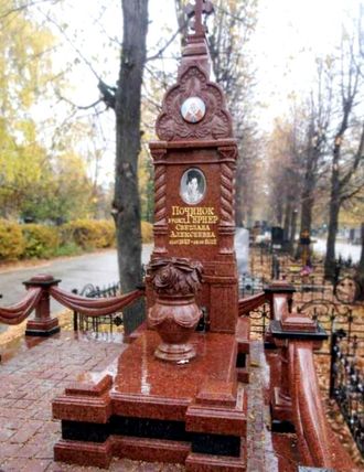 Памятник из красного гранита оригинальной формы в виде часовни