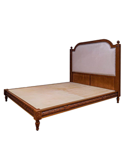 Кровать резная с высоким мягким изголовьем.