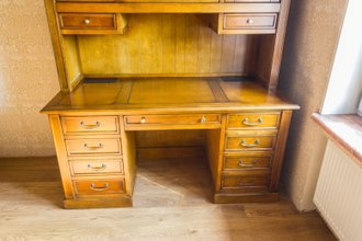 Письменный стол с высокой надстройкой с полками и ящиками.