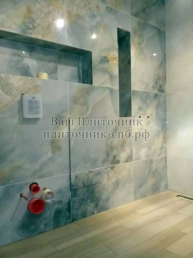 Облицовка стен в ванной комнате керамогранитом 80*80 см. Заусовка плитки под 45 градусов на углах в нишах.