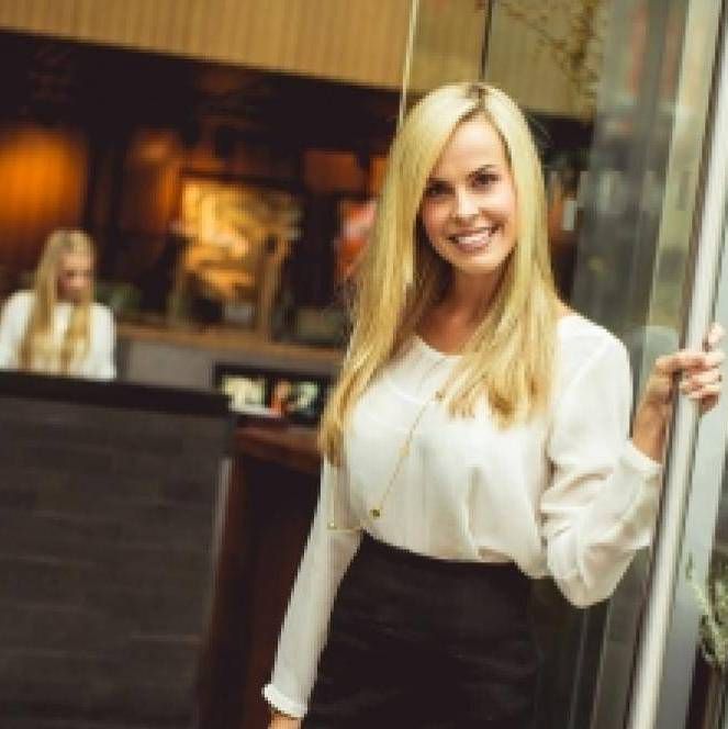 Блондинка с длинными волосами встречает клиентов салона красоты и СПА