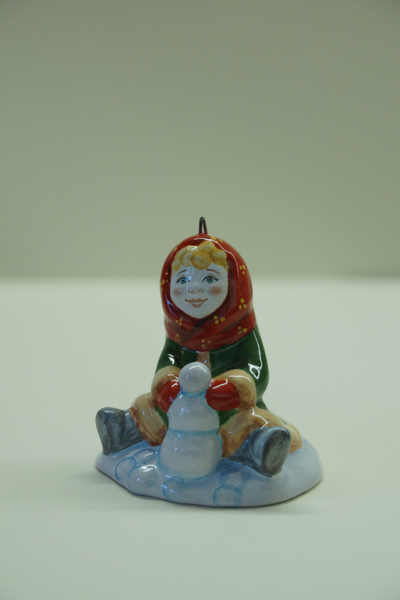 Девочка лепит снеговика - зимние забавы