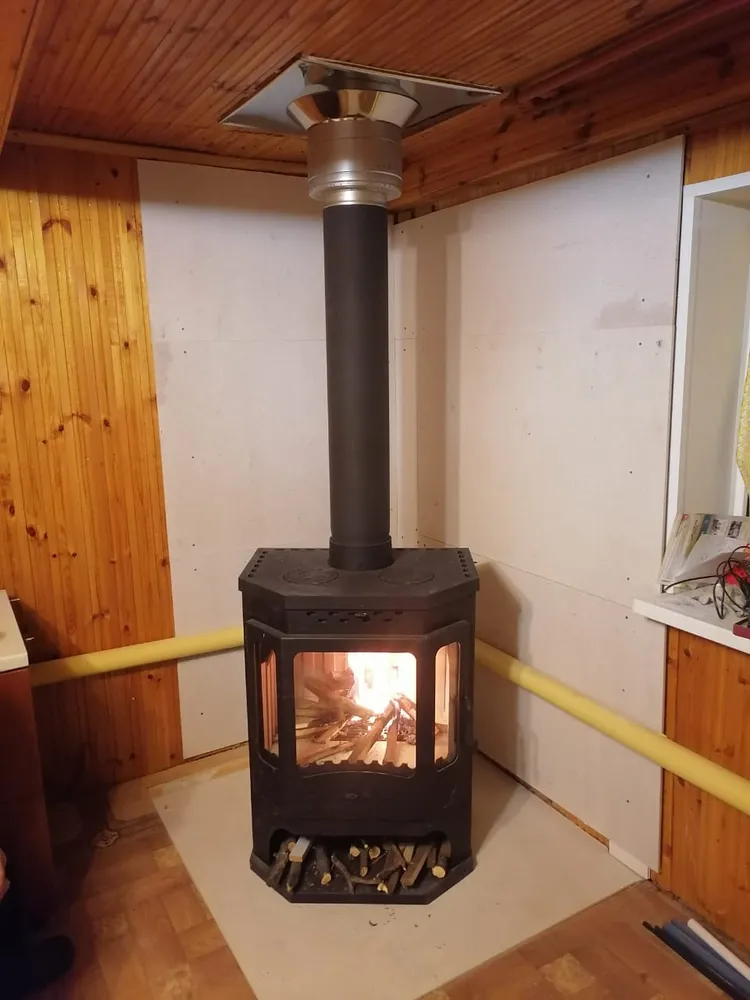 Печь-камин БАВАРИЯ призматик с чугунной плитой и теплообменником (Экокамин). Под потолком закрашивают в черный. Подключение в систему отопления дома.