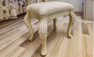 Пуф с мягким сиденьем на резных ножках.