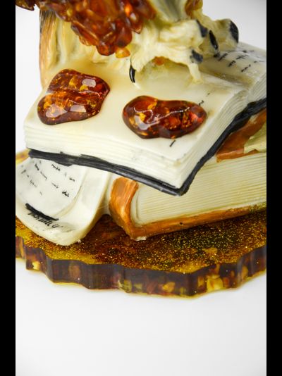 Сова с пером на книгах на подставке