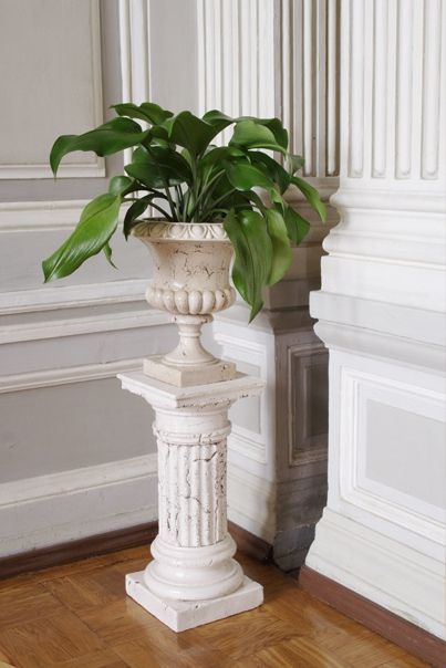 Вазон цветами на пьедестале в углу комнаты