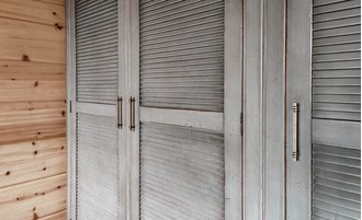 Шкаф для одежды на мансарду с жалюзийными дверьми.