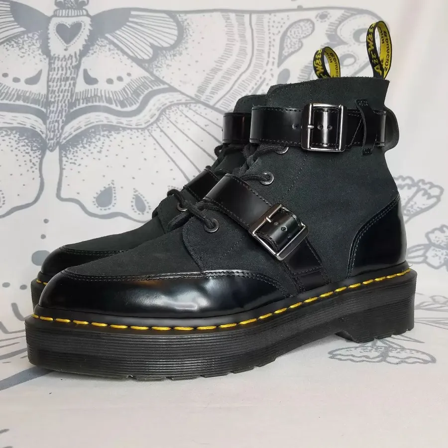 Черные ботинки DR. Martens из натуральной кожи украшены ремешками и представлены в размере от 36 до 45.