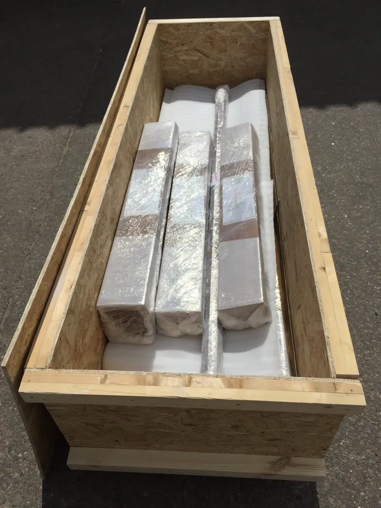 Пример жесткой упаковки, которую мы используем для перевозки стеновых панелей и штапика из массива дерева длиной 2,2 метра - изготовленный деревянный ящик, выставленный на паллеты.