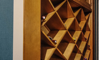 Встроенный винный шкаф с резными декорами на дверях.