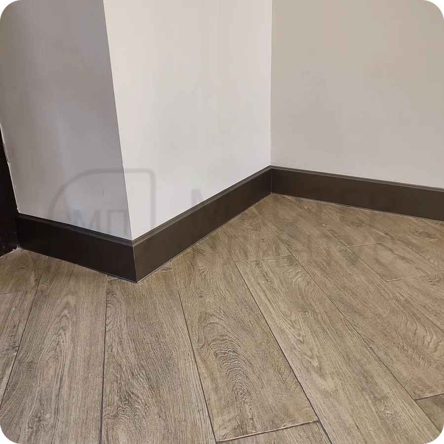 Практичная роскошь: монтаж плинтуса Dollken сочетает в себе практичность гибкого материала и роскошный бронзовый дизайн.