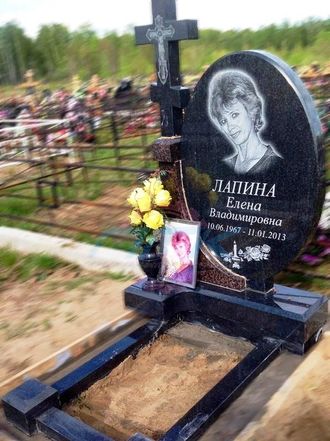 На фото круглый памятник на могилу с черным крестом в СПб