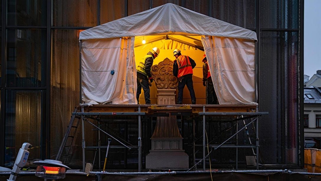 Монтаж полиуретанового карниза в тёплой монтажной палатке &mdash; рабочие прогревают деталь перед к