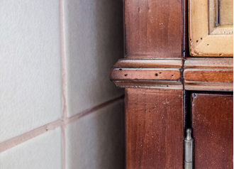 Тумба под раковину со столешницей из плитки с деревянным краем.