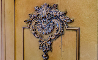 Шкаф для одежды с резным декором на фасадах и нижним ящиком.