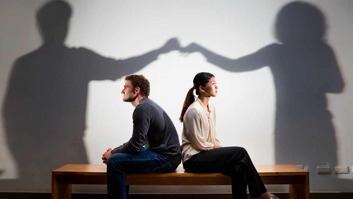 Пара сидит спиной друг к другу - психолог в отношениях мужчины и женщины