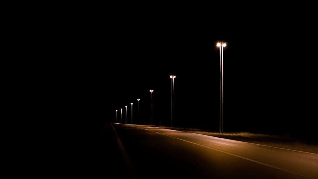 Вид на ночное шоссе с идеально выверенным расстоянием между высокими опорами освещения.