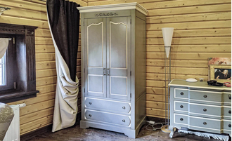 Шкаф для одежды двухстворчатый с ящиками и верхним декором.