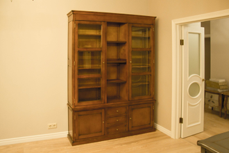 Книжный шкаф со стеклянными дверьми и открытой частью.